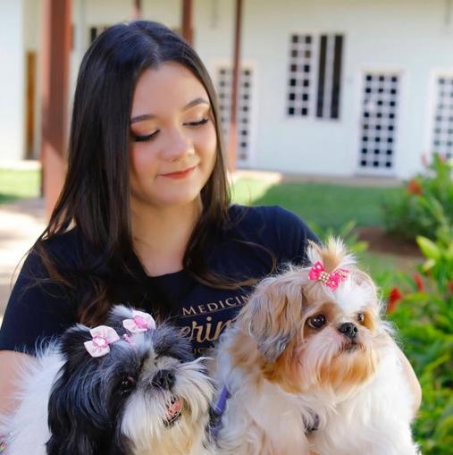 Foto de perfil da Médica Veterinária Luisa Pol de Almeida, ela está olhando para a camera sorrindo e segura o estetoscópio.